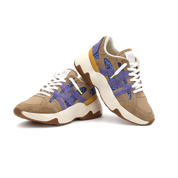 Sneakers Améthyste positionnées l’une sur l’autre, montrant l’alliance de couleurs beige, violet, et détails brillants.