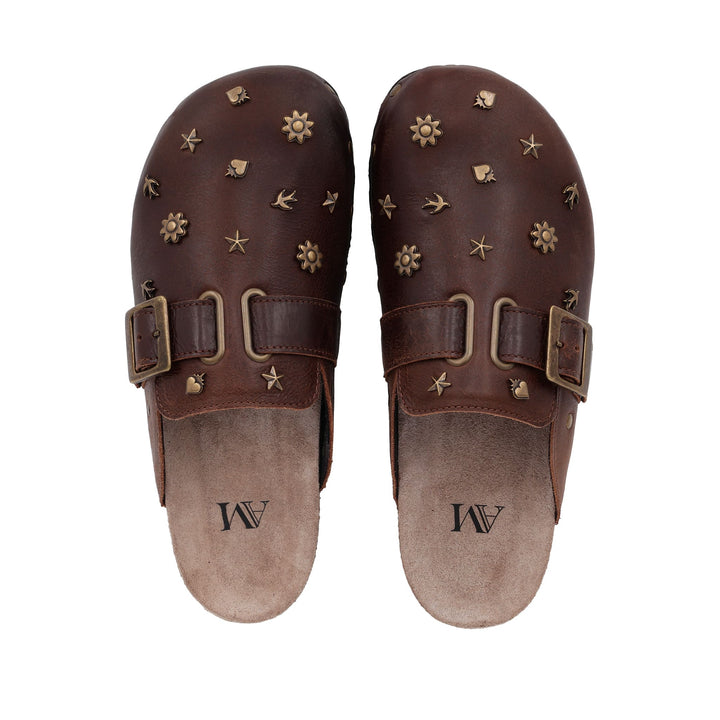 Vue du dessus des sabots en cuir vieilli AM – semelle intérieure beige avec logo et détails décoratifs en laiton